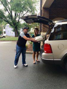 Staff loading cars to transport the first shipment of diapers from the Diaper Bank to the Catholic Charities office.