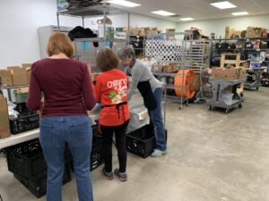 Volunteers work to pack boxes of food.